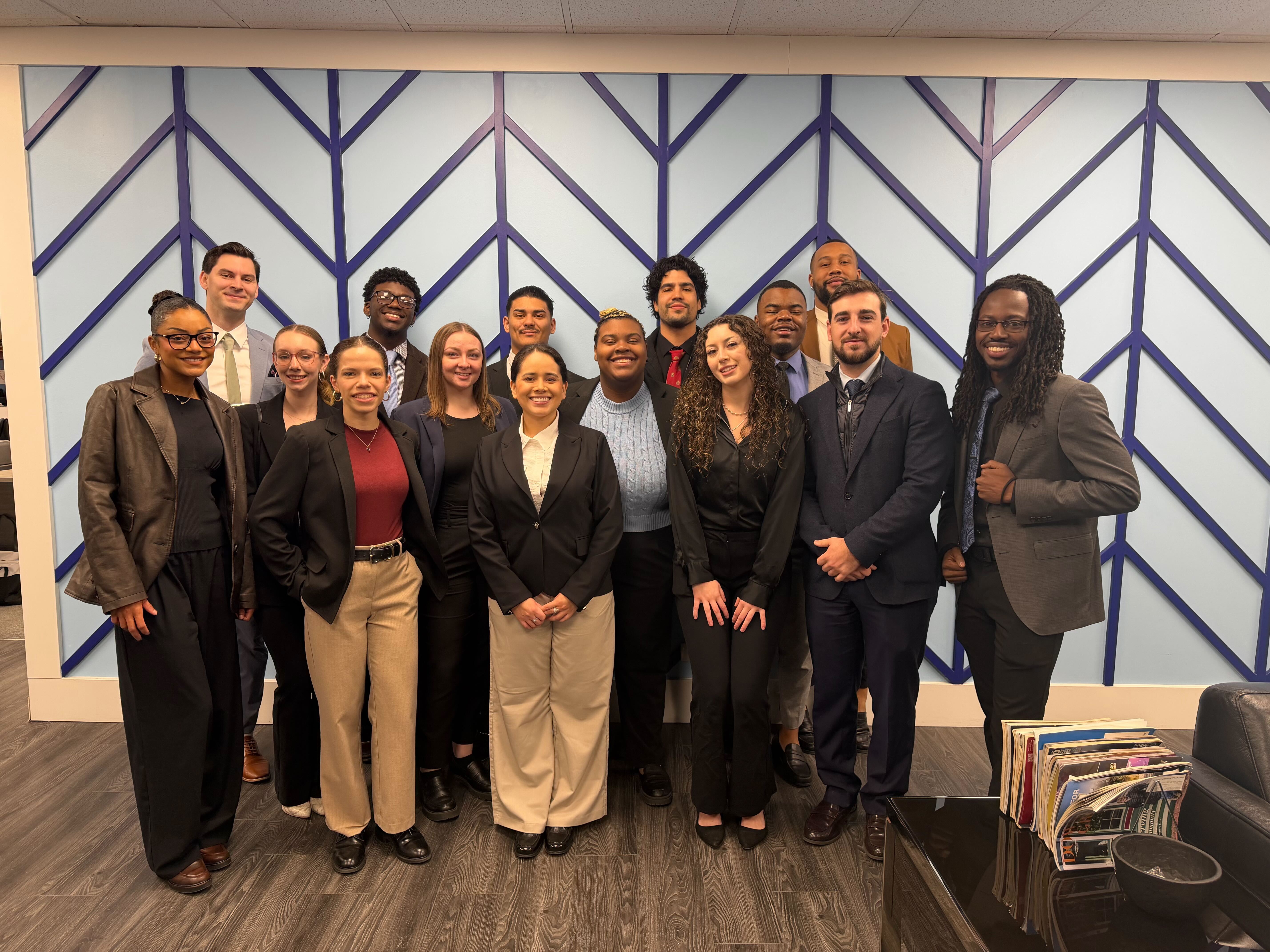 Reformed Marketing team in the office with blue chevron backdrop